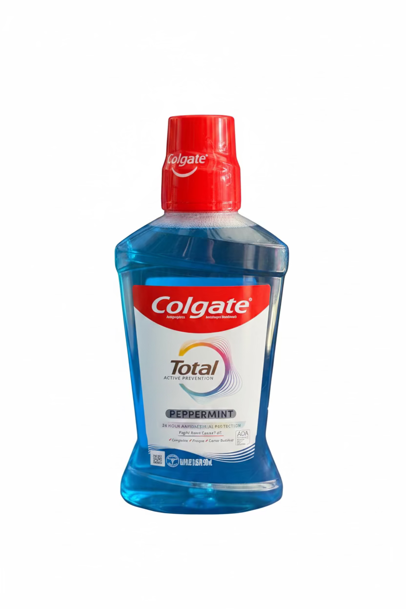 Colgate Total mouthwash bottle on a blue surface with a blurred background